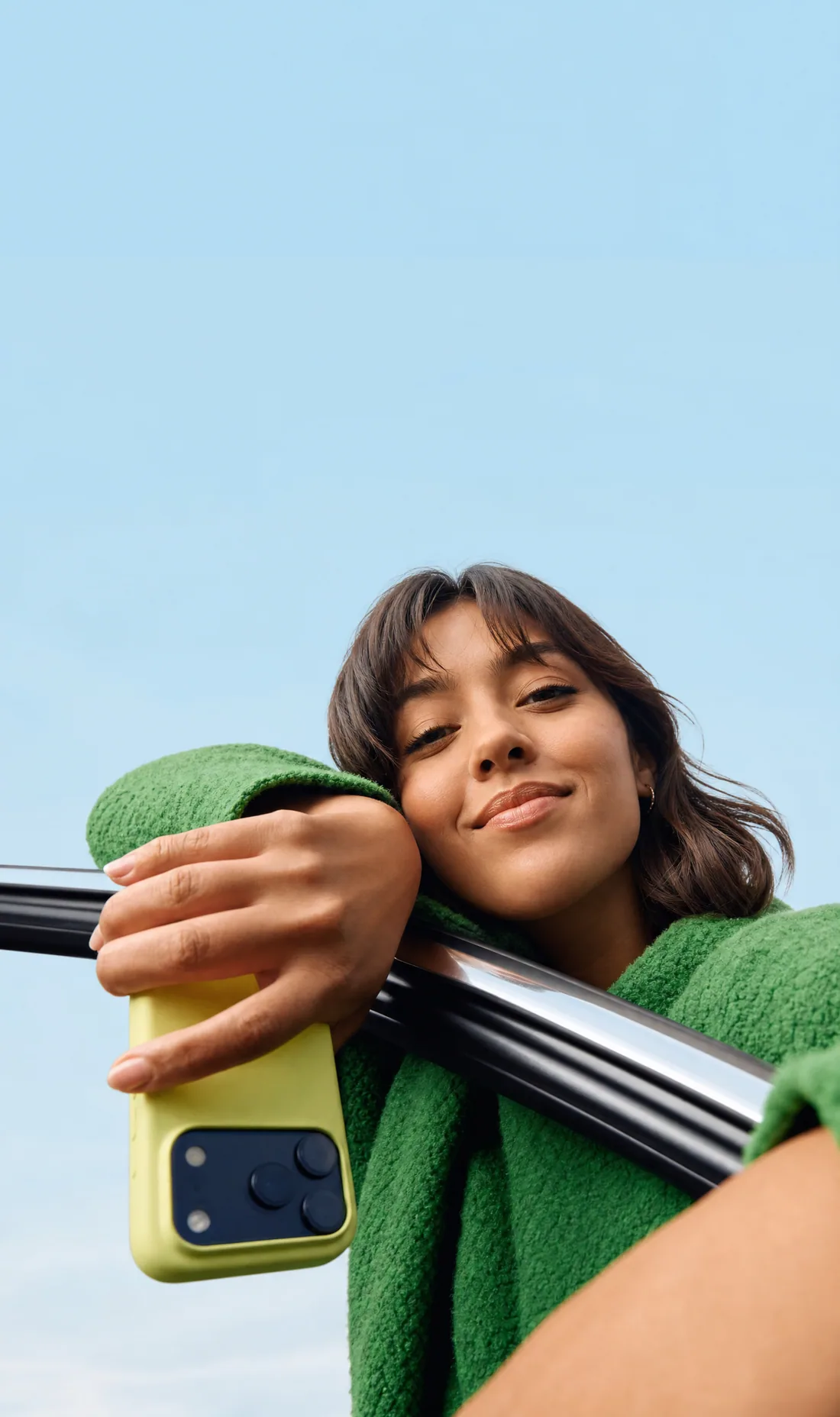 A smiling traveler leaning out of a car holding her phone
